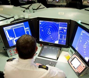 A Navy operator works at a sonar system on a warship