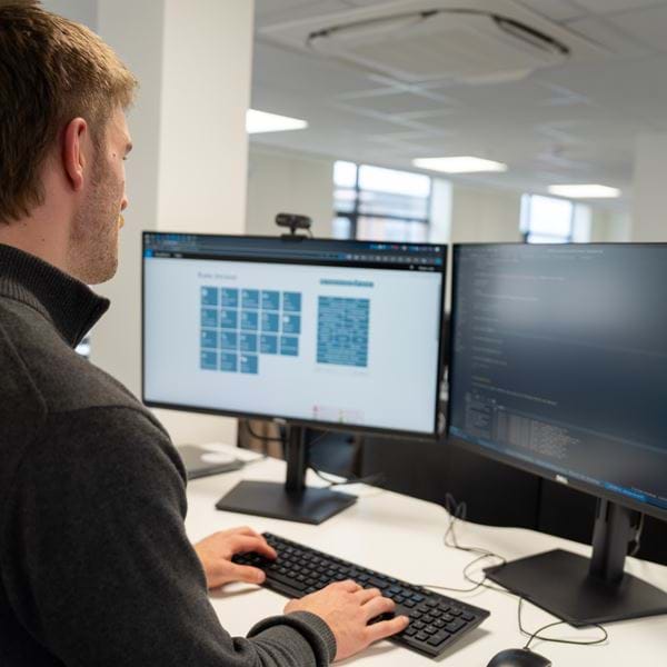 Code on a screen with people in the background