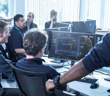 Seven male Roke engineers work at computers as part of an innovation excercise.