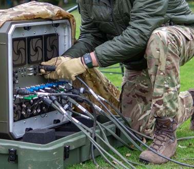 A military technician plugs in cables