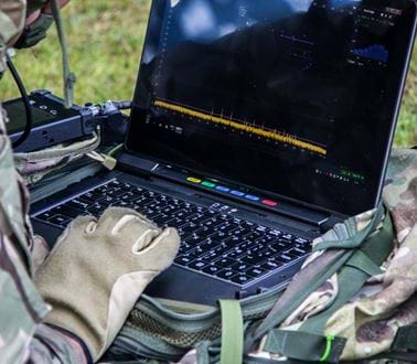 A soldier using the VIPER software on a ruggedised laptop