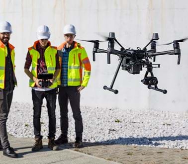 Construction workers control a drone