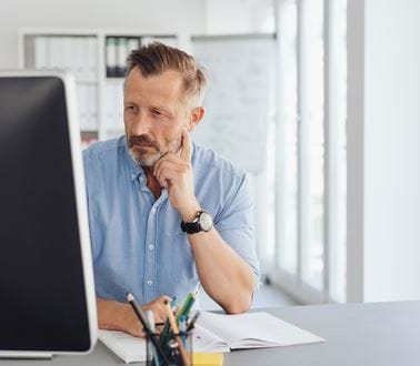 Middle aged man works at a computer in an office