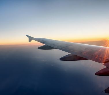 the wing of a passenger jet at sunset