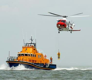 A lifeguard boat and helicopter rescue someone at sea